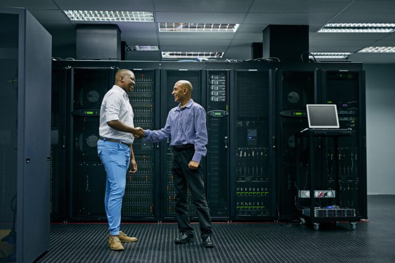 IT support you can trust. Shot of two men shaking hands in a data center.