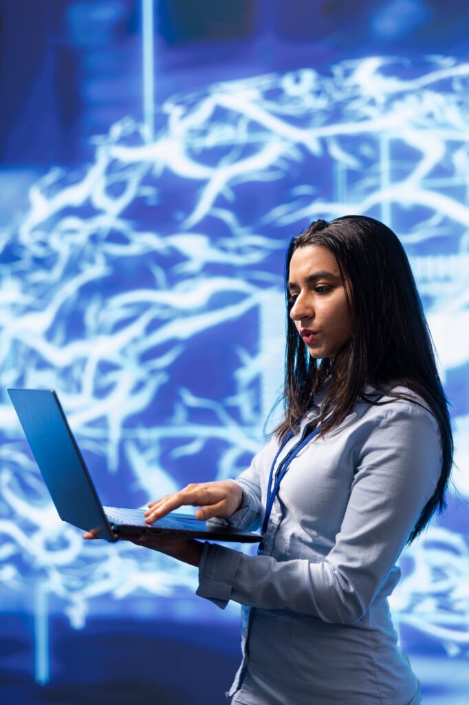Woman in modern lab using notebook to write lines of code for AI applications