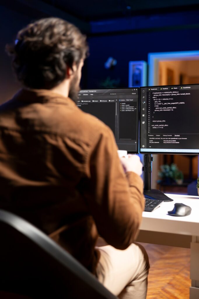IT admin inspecting coding on desktop PC, looking to fix potential issues