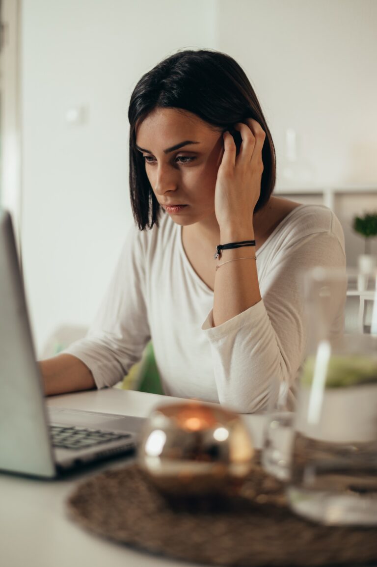 Woman feeling tired and stressed while using a laptop and working from home
