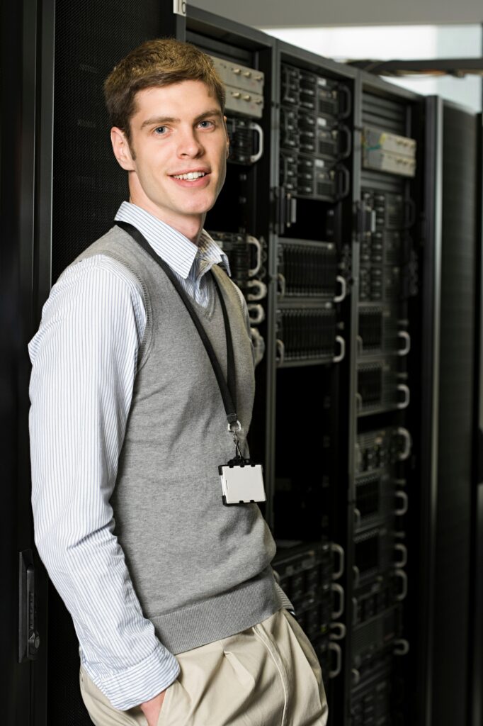 Confident young professional posing in a data center