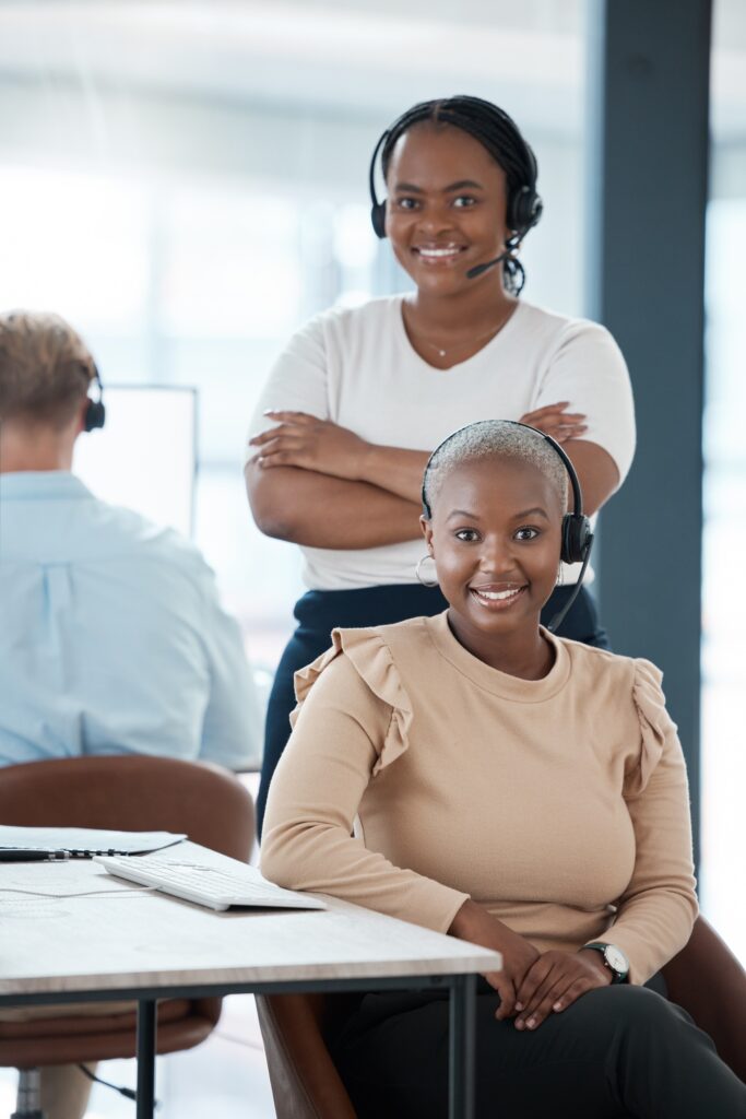 Happy, black woman and call center team smile in contact us, customer service or telemarketing at t