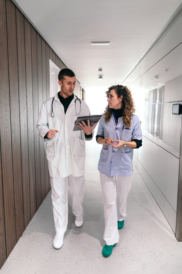 Healthcare Staff Conversing on Patient Care in Corridor