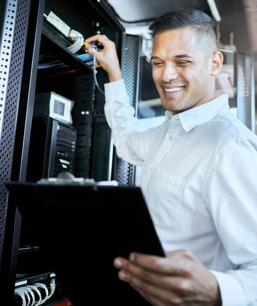 Server room, IT support and database with a man programmer working on a mainframe in a data center.