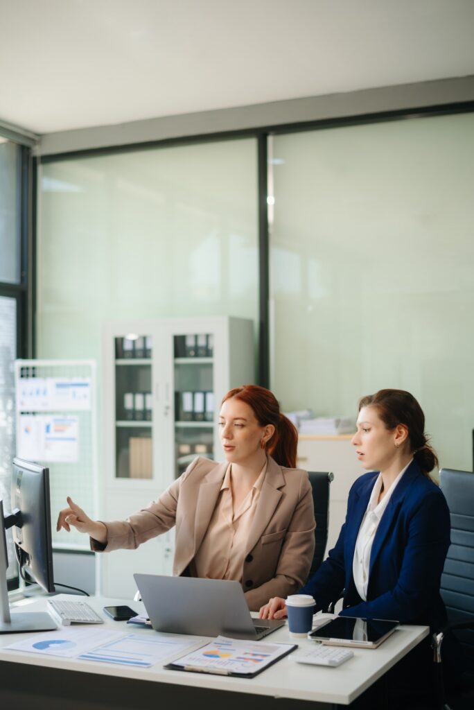 Businesswoman leading team meeting and using tablet and laptop computer with financial