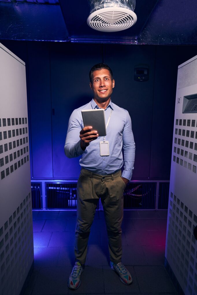 Cheerful data center employee with tablet computer