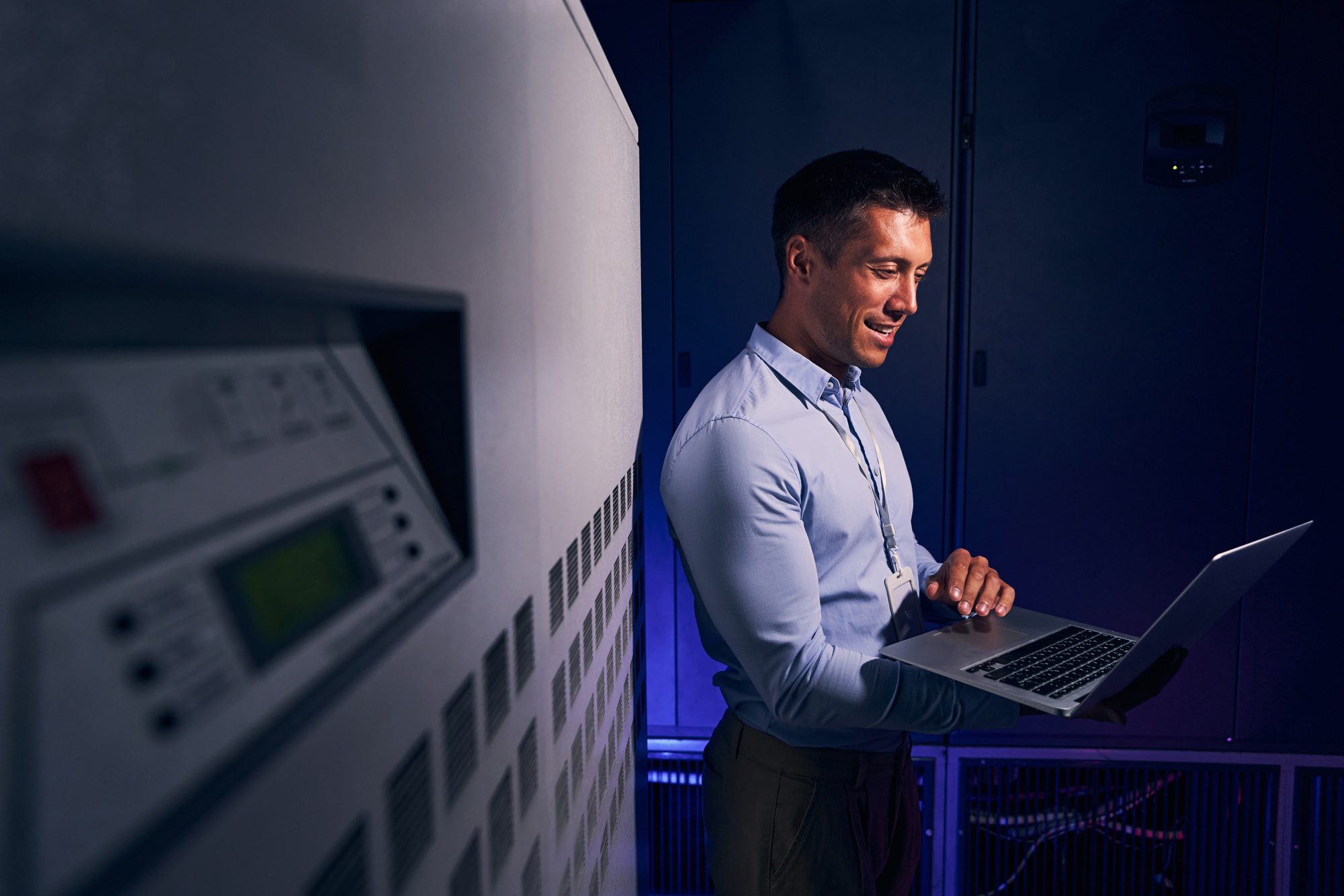 Cheerful male employee working in data center