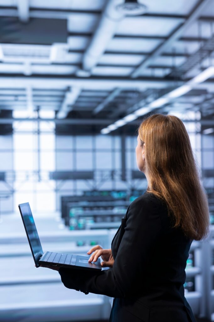 Software developer walking between server rows in data center