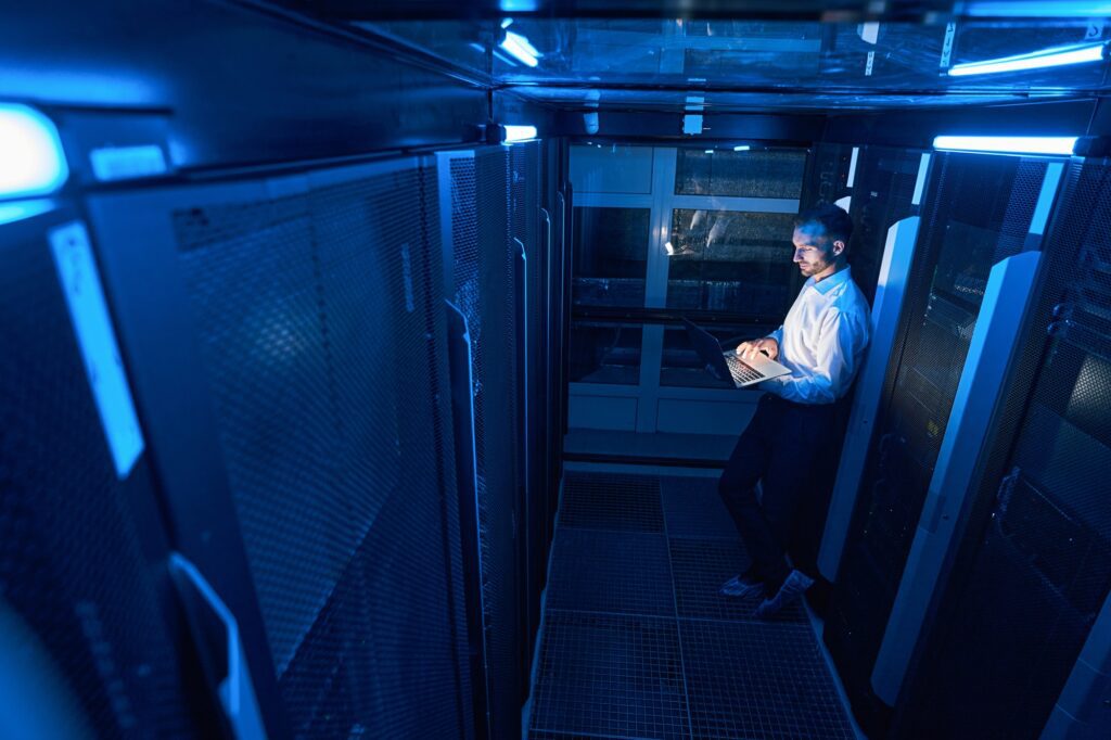 Data center operations professional programming server with laptop